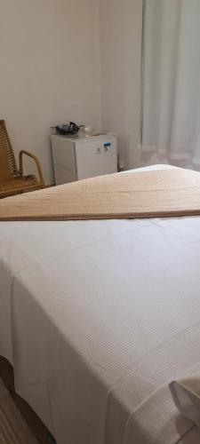 a close up of a white bed in a room at Nosso Recanto Pérola in Capitólio