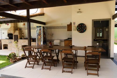 a patio with two wooden tables and chairs at Pousada Kactus in São João da Barra