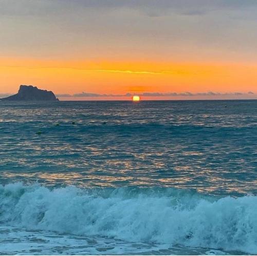 a sunset over the ocean with the sun in the distance at Cosy flat with magnificent views in L'Albir in Albir