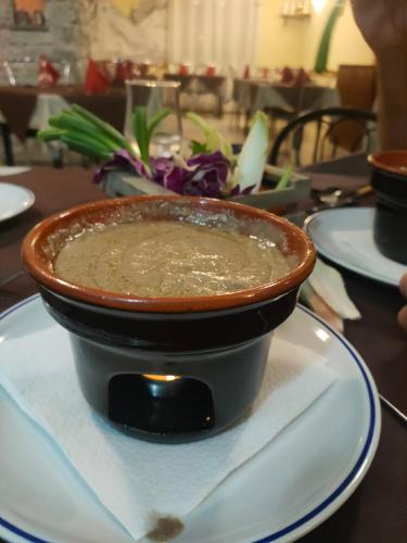 a bowl of soup sitting on a plate on a table at Locanda mami in Aosta