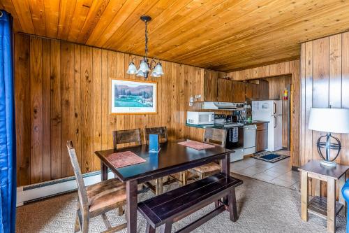 a dining room with a table and a kitchen at Bay Point Lakefront 1B Down in Whitefish