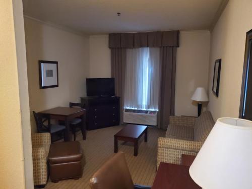 a living room with a couch and a table and a television at The Arc Hotel in Fort Smith