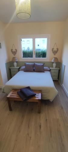 ビリャヌアにあるvilla cocoloの大きなベッドと2つの窓がある寝室