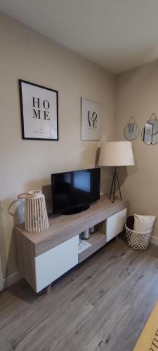 ビリャヌアにあるvilla cocoloのリビングルーム(テレビ、ランプ付きテーブル付)