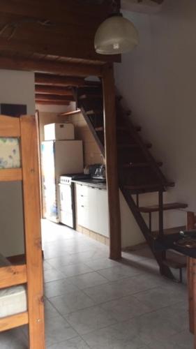 Habitación con una escalera que conduce a una cocina con nevera. en LATOMASITA2, en San Clemente del Tuyú