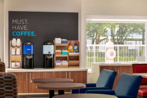 Ein Café mit blauen Stühlen und einem Schild mit der Aufschrift „Unbedingt probieren!“ in der Unterkunft Holiday Inn Express & Suites Pembroke Pines-Sheridan St by IHG in Pembroke Pines
