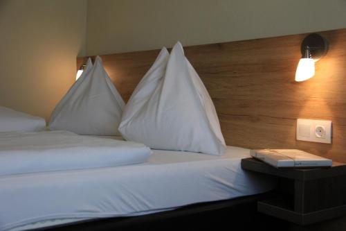a hotel room with a bed with white pillows at Hotel Lindenhof in Bad Gastein