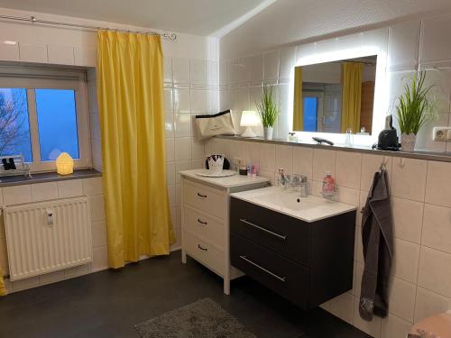 a bathroom with two sinks and a mirror at Meerblick Apartments Villa Vineta Göhren in Göhren