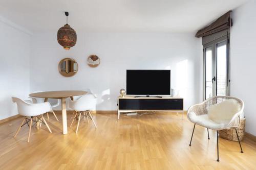 ein Wohnzimmer mit einem Tisch, Stühlen und einem TV in der Unterkunft Hauzify I Apartamento Ramon y Cajal in Santa Cruz de Tenerife