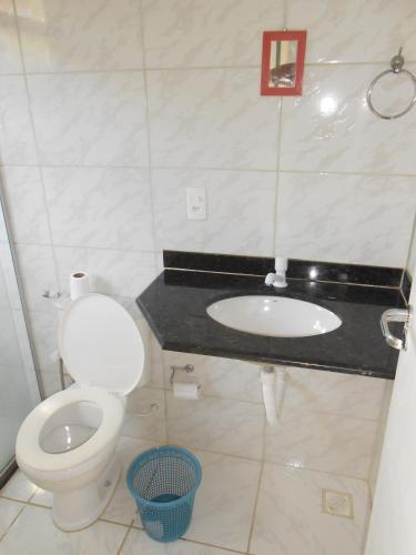 a bathroom with a toilet and a sink at Casa de Vidro in Itacaré
