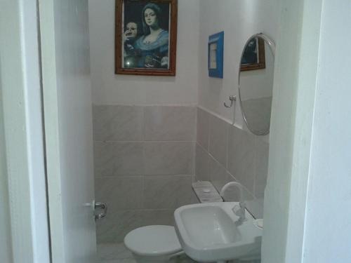 La salle de bains est pourvue de toilettes, d'un lavabo et d'un miroir. dans l'établissement Casa de Vidro, à Itacaré