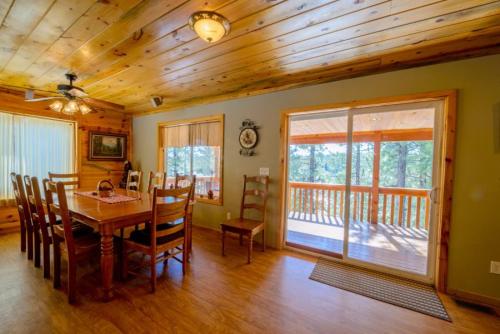 a dining room with a table and wooden ceilings at S`more Fun Cabin in Duck Creek Village