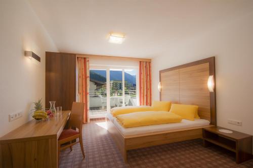 ein Hotelzimmer mit einem Bett, einem Schreibtisch und einem Schreibtisch in der Unterkunft Apart Mado in Längenfeld