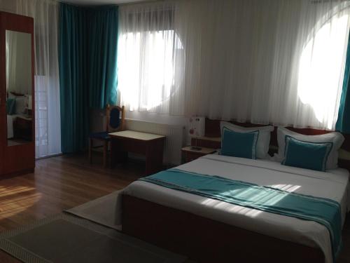 a bedroom with a large bed with blue pillows at Marina House in Sulina