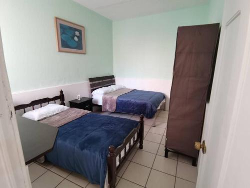 a room with two beds and a door to a bedroom at Encantador - céntrico - apacible departamento en la Roma Norte. in Mexico City
