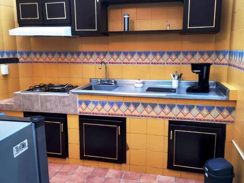 a kitchen with a sink and a stove at Encantador - céntrico - apacible departamento en la Roma Norte. in Mexico City