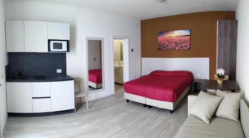 a bedroom with a red bed and a couch at Tenuta da Rino - Agriturismo Barco Menti in Vicenza