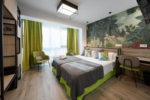a hotel room with a bed and a large painting on the wall at Enmathi Alicante Benalua in Alicante