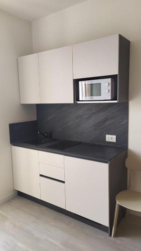 a kitchen with white cabinets and a microwave at Tenuta da Rino - Agriturismo Barco Menti in Vicenza