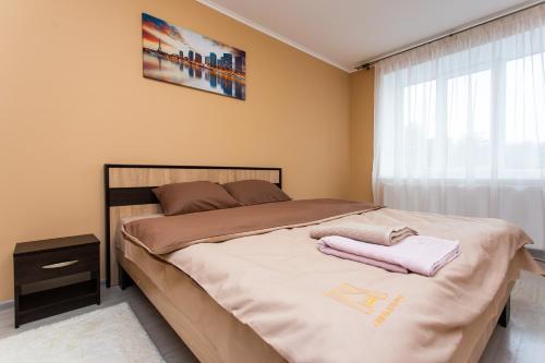 1 dormitorio con 1 cama con 2 toallas en Бам. Однокімнатна квартира в новобудові, en Ternopilʼ
