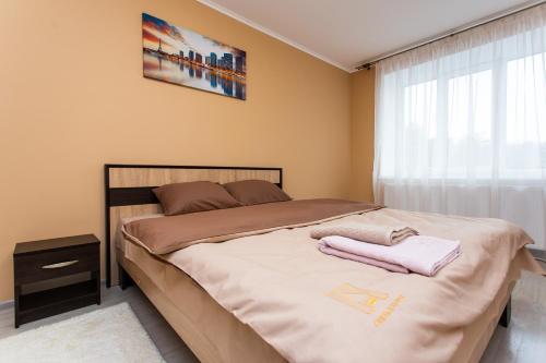 a bedroom with a bed with two towels on it at Бам. Однокімнатна квартира в новобудові in Ternopilʼ