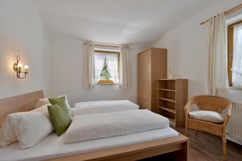 a bedroom with a large bed and a chair at Ferienwohnung Rahm in Schwendau