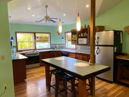 a kitchen with a table and a refrigerator at Mariposa Lodge in West End