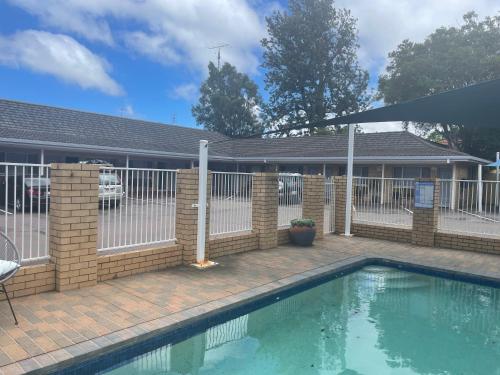 
a patio with a pool and a swimming pool at Blue Violet Motor Inn in Toowoomba
