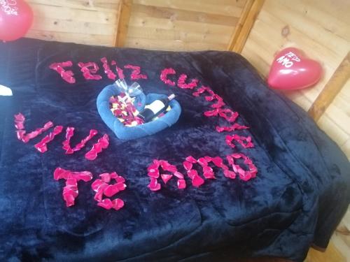 una torta nera con sopra una scritta rosa di Cabañas el mirador del tomine a Guatavita