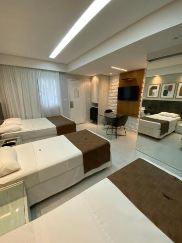 a large bedroom with two beds and a living room at Bianca Praia Hotel in Recife