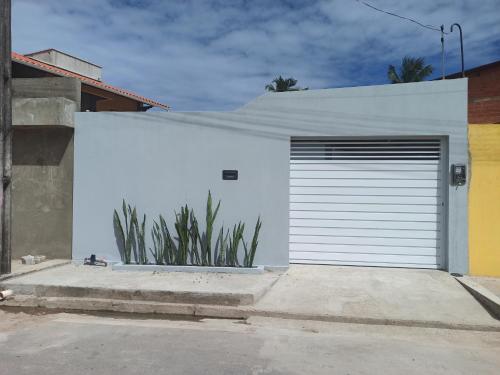 a white garage door on a white building at Casa em São Miguel dos milagres. in São Miguel dos Milagres