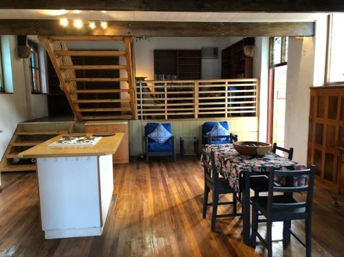 a room with a table and chairs and a kitchen at La Chapelle - The Library in Montagu