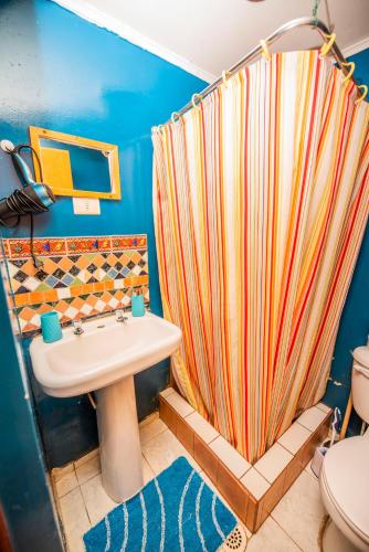 a bathroom with a shower curtain and a sink at Incahuasi Travelodge in San Pedro de Atacama