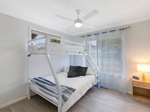 a bedroom with a bunk bed and a window at Bonnieview House in Shelly Beach
