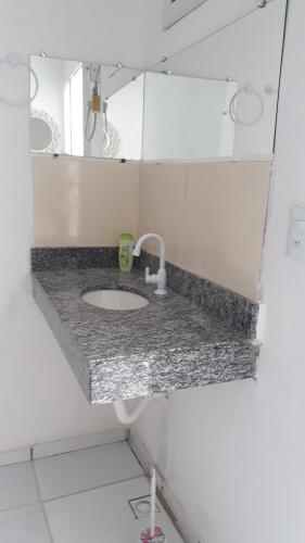 encimera con lavabo y espejo en Suíte 1 Zona Sul Ilhéus próximo a praia en Ilhéus