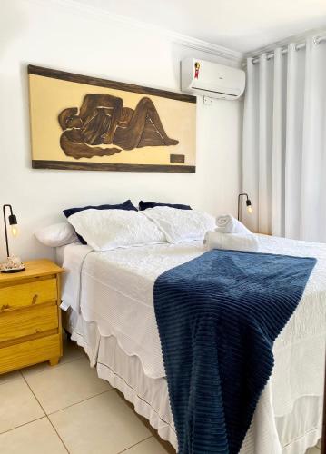 a bedroom with a bed with a blue blanket on it at Cobertura Duplex: piscina, três quartos e beira á mar in Ilhéus