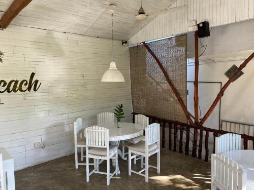 a dining room with a white table and chairs at Una Beach Hotel & OLU Cafe in Unawatuna