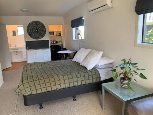 a bedroom with a bed and a couch and a table at Long St Studio in Raglan