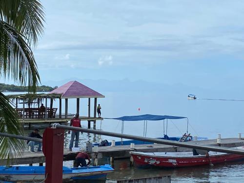 a dock with boats on the water with people on it at Mariposa Lodge in West End