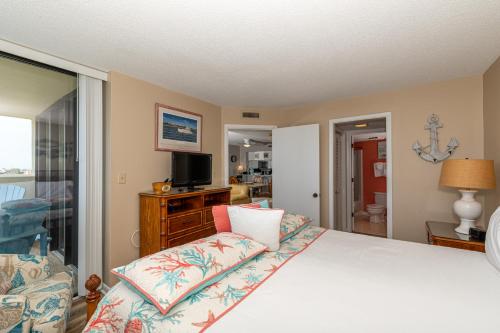 um quarto com uma cama grande e uma televisão em Sands Villas II em Atlantic Beach
