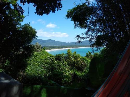a view of a beach from a hill with trees at Hostel do Morro in Florianópolis