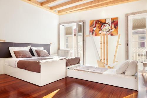 Habitación blanca con cama y sofá en Stay in the heart of Porto! en Oporto