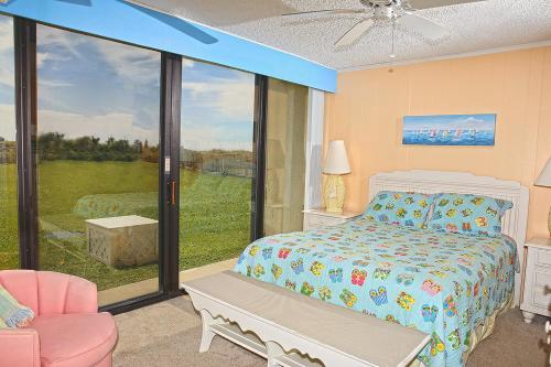 1 dormitorio con cama y ventana grande en Smuggler's Cove, en Atlantic Beach