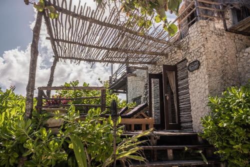 an outside view of a house with a pergola at Playa Esperanza Tulum in Tulum