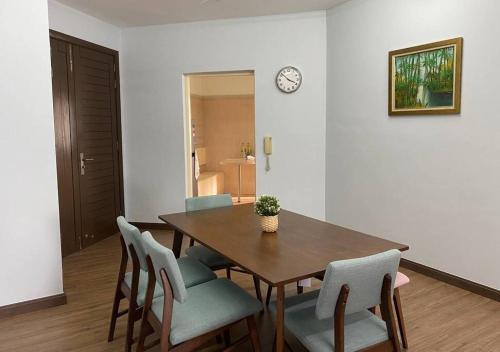 a dining room table with chairs and a clock on the wall at Spacious 3 rooms Apartment@Desa Putra Condominium in Kuala Lumpur