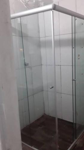 Una ducha acristalada en una habitación con paredes blancas. en N1 2 Apto Pequeño Habitación con baño privado a 120 metros de Plaza Batlle punto Central de la Ciudad, en Artigas