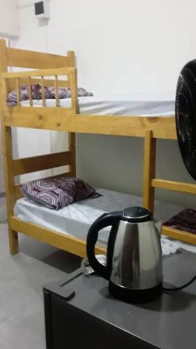 a tea kettle on a desk next to a bunk bed at N1 2 Apto Pequeño Habitación con baño privado a 120 metros de Plaza Batlle punto Central de la Ciudad in Artigas