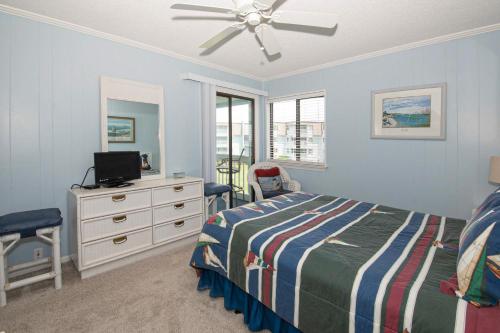 1 dormitorio con 1 cama y vestidor con TV en Seaspray II en Atlantic Beach
