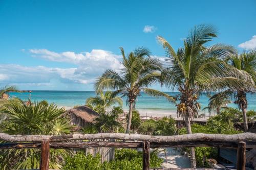 a view of a beach with palm trees and the ocean at Playa Esperanza Tulum in Tulum