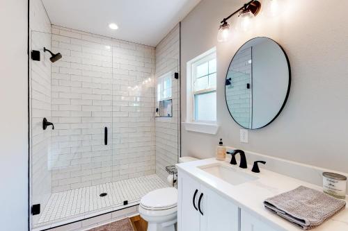 a white bathroom with a sink and a mirror at Downtown Livin' in Pensacola